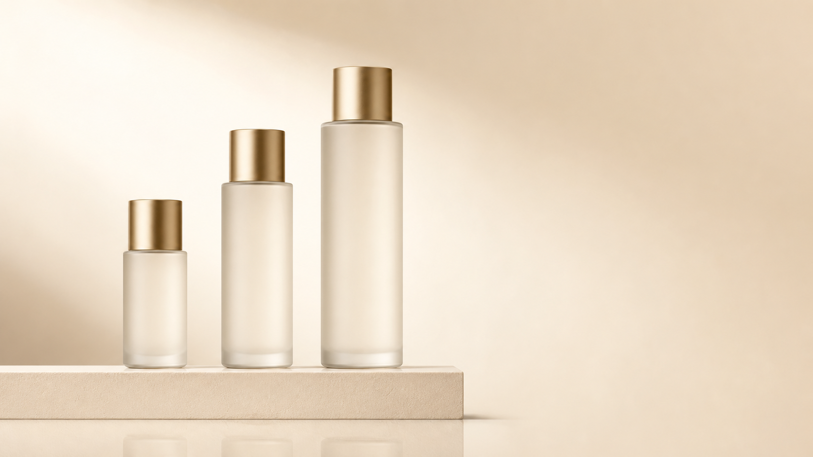 Three frosted glass bottles of ascending size on a cream pedestal